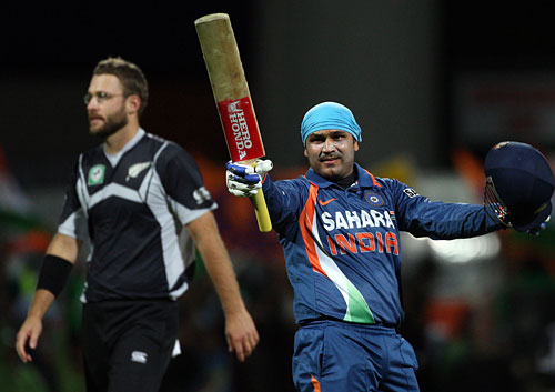 Virender Sehwag raises his bat after reaching his century