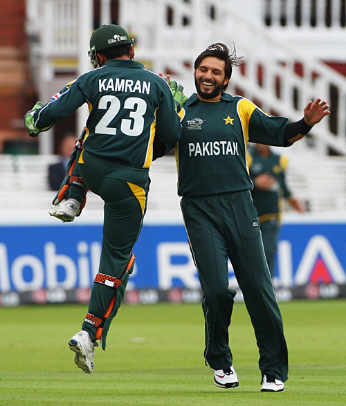 Shahid Afridi gets a high five from Kamran Akmal after bowling Tom de Grooth