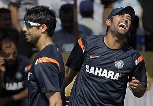 Ashish Nehra and MS Dhoni share a joke during a training session