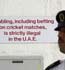 A security guard at Sharjah stadium stands in front of a sign prohibiting gambling and betting