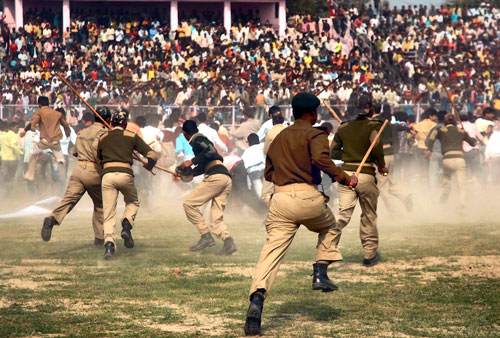 Indian policemen use batons to disperse fans who rushed onto the pitch during a friendly Twenty20 tournament in Patna, India, January 19, 2009